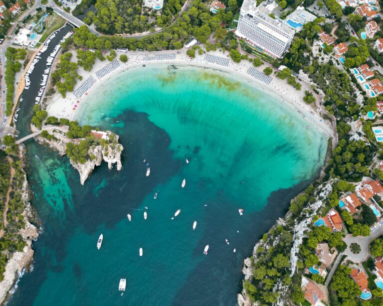 Calas de Minorque vues du ciel, eau turquoise, falaises blanches, catamaran
